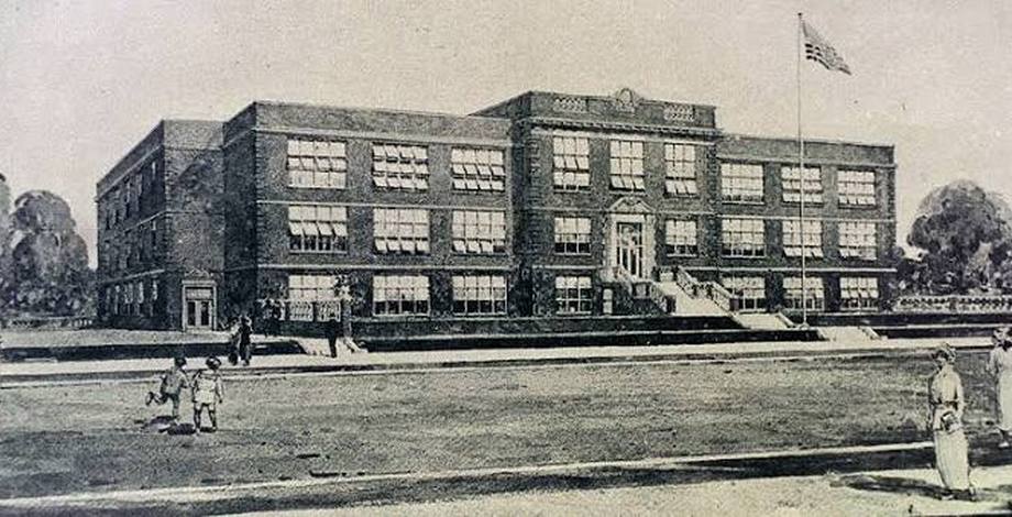 Oak Cliff High School not long after it opened in 1915, with students on the lawn.